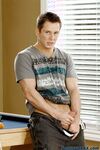 Cute gay Tommy D undresses, grabs his cock and poses on the