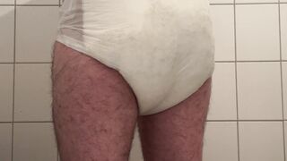 Nappy twink wearing a full nappy under his suit at work