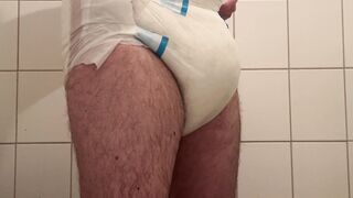 Nappy twink wearing a full nappy under his suit at work