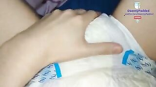 Wet morning: Twinky diaper boy squishes soaked diaper in the bed