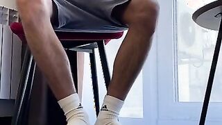 A MAN WITH HAIRY LEGS IN WHITE SOCKS ADIDAS JERKS OFF A
