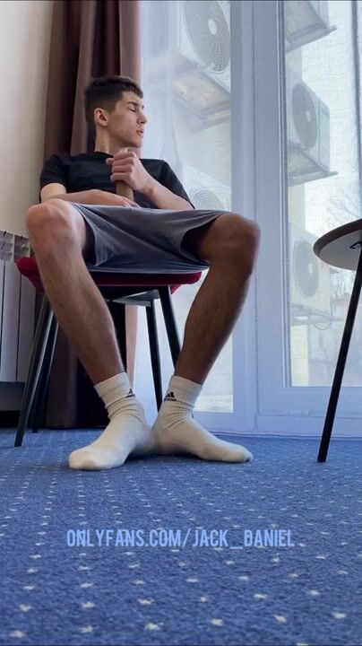 A MAN WITH HAIRY LEGS IN WHITE SOCKS ADIDAS JERKS OFF A